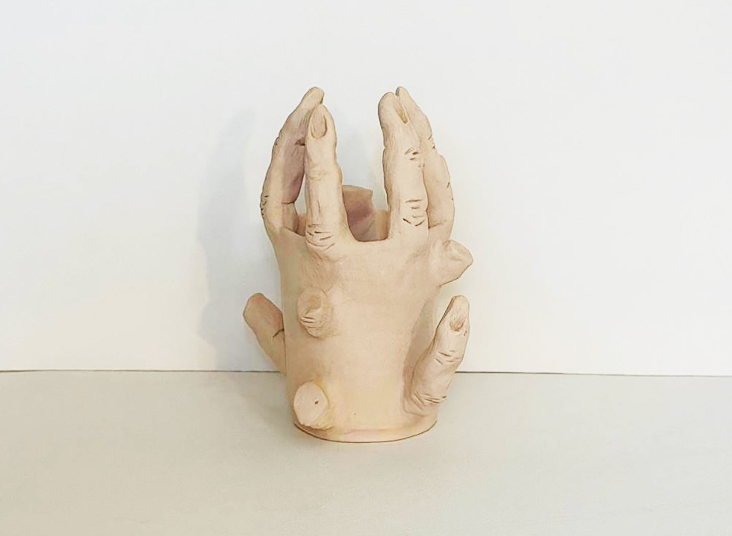 Severed fingers, ceramic vessel formed as a hand with fingers rising from the rim