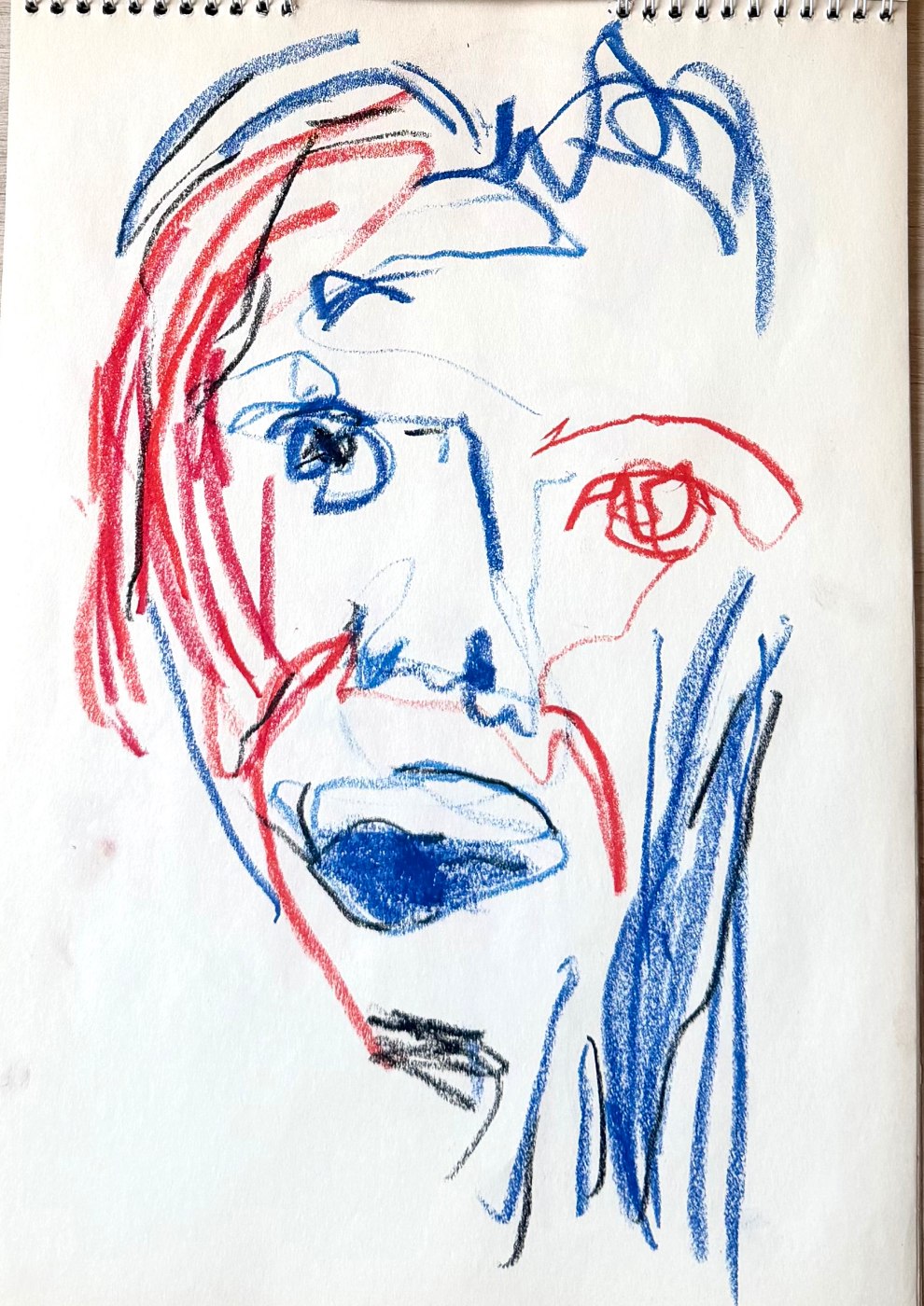 Self-portrait study in red and blue oil pastel, the face split between the two colours